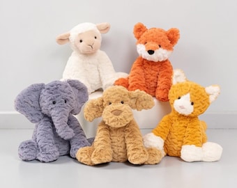 May include: A collection of five plush animal toys: a white lamb, an orange fox, a lavender elephant, a tan dog, and an orange and white cat. Each stuffed animal has a soft, textured appearance and is sitting upright.