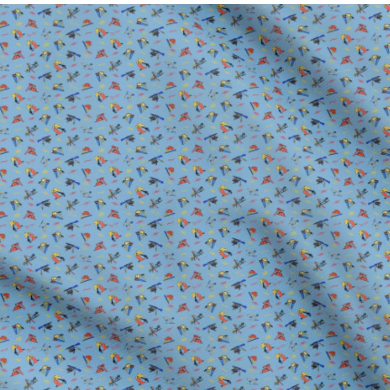 May include: Light blue fabric with a repeating pattern of colorful toucans, dragonflies, and small geometric shapes. The toucans are red, yellow, and black, while the dragonflies are blue and black. The fabric has a slightly wrinkled texture.