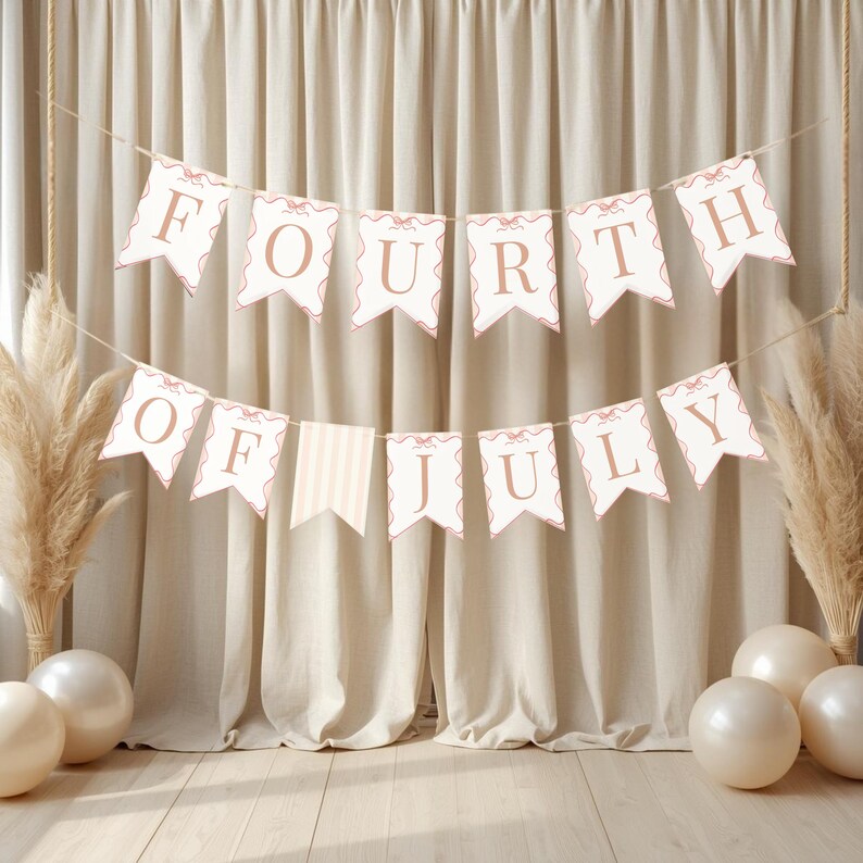 May include: A banner with the words "FOURTH OF JULY" in a light brown font, strung across a neutral-toned background. The banner flags are white with a scalloped edge and a light brown border. Decorative elements include balloons and pampas grass.