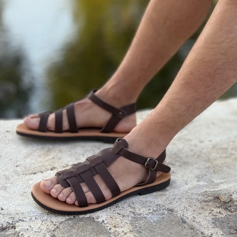 Pu&ograve; includere: Sandali in pelle marrone con un design intrecciato e cinturini alla caviglia. I sandali hanno una suola marrone chiaro e una chiusura con fibbia. Questi sandali sono un'opzione di calzature elegante.