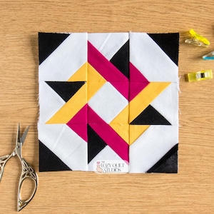 May include: A square quilt block with a geometric design in white, black, yellow, and magenta. The block is on a wooden surface, with small sewing clips and scissors nearby. The Cozy Quilt Studios logo is visible.