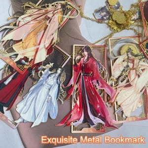 May include: Ornate metal bookmarks with illustrations of figures in flowing robes. The bookmarks are in gold and red tones, with intricate designs and the text "Exquisite Metal Bookmark".