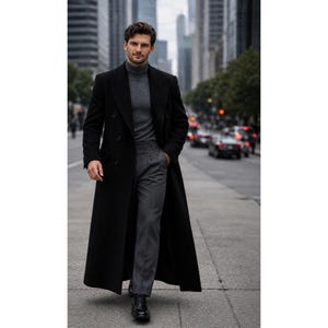 Puede incluir: Un abrigo largo negro de doble botonadura sobre un suéter de cuello alto gris y pantalones grises. El conjunto se completa con zapatos de vestir de cuero negro. El abrigo presenta solapas anchas y un corte estructurado bajo las rodillas.
