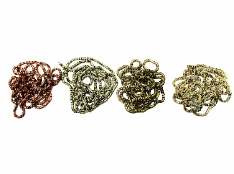 Puede incluir: Cuatro carretes de cord&oacute;n trenzado en diferentes colores: cobre, oro y dos tonos de verde. El cord&oacute;n est&aacute; trenzado y apilado en un mont&oacute;n suelto.