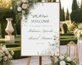 Può includere: Un cartello di benvenuto rettangolare bianco per matrimonio con cornice in legno, decorato con composizioni floreali negli angoli in alto a sinistra e in basso a destra. Il testo recita: Bismillah, WELCOME TO THE NIKKAH CEREMONY OF Mahnoor Qureshi & Ahmed Humair 14.08.2025.