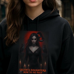 May include: Black hoodie featuring a graphic of a woman with dark hair, two owls, and candles, set against a red backdrop. The text "LILITH'S DAUGHTERS BOW TO NO MAN" is printed at the bottom of the graphic.