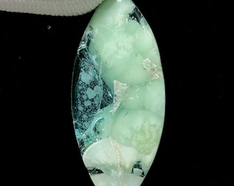 May include: An elongated gemstone, polished to a high sheen, displaying a blend of light green and teal hues. The stone's surface features an intricate, natural pattern, and it has a translucent appearance. The shape is similar to a marquise cut.