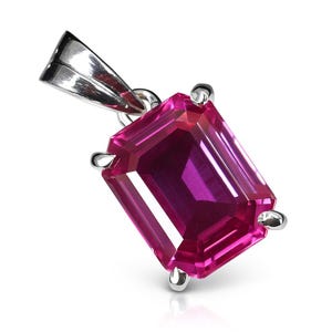 Op de afbeelding: Een rechthoekige, magenta edelsteen hanger met een zilveren beugel. De edelsteen heeft een diepe, rijke kleur en wordt op zijn plaats gehouden door vier zilveren klauwen. De hanger is ontworpen om als ketting te worden gedragen.