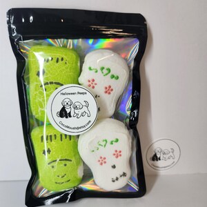 May include: A black cellophane bag contains four Halloween-themed marshmallow treats. Two green Frankenstein-shaped marshmallows and two white skull-shaped marshmallows are visible. The bag has a round sticker that says "Halloween Peeps" and "CocoMoush@etsy.com".