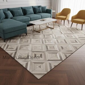 Puede incluir: Salón moderno con un sofá seccional turquesa, una mesa de centro con tapa de mármol y marco dorado, y dos sillones amarillos. Una alfombra con estampado geométrico en tonos grises y beige cubre el suelo. El texto "Marlen Rug Decor" es visible.