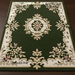 May include: A rectangular green rug with an ornate floral design. The rug features a central medallion and a border with cream, pink, and gold floral patterns. The text "Marlen Rug Decor" is visible in the corners.