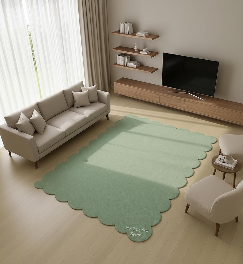 Puede incluir: Una alfombra verde salvia con bordes festoneados en un sal&oacute;n. La alfombra est&aacute; colocada sobre un suelo de madera clara, con un sof&aacute; beige, dos sillones y un mueble de TV de madera. La alfombra tiene el texto "MarLen, Rug Decor".