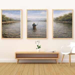 Könnte beinhalten: Set aus drei gerahmten Landschaftskunst-Drucken. Die Drucke zeigen eine ruhige Flussszene mit einer Person, die im Wasser fischt. Das Kunstwerk zeichnet sich durch eine natürliche Farbpalette mit Fokus auf Wasser, Bäume und Himmel aus.