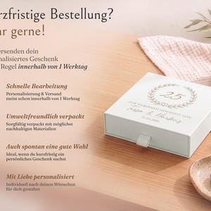 Pu&ograve; includere: Una scatola regalo quadrata bianca con cassetto estraibile, decorata con una corona stampata, il numero 25 e il testo "Zur silbernen Hochzeit von Tessa & Markus 31.03.2001". La scatola presenta una piccola linguetta in tessuto bianco sul davanti.
