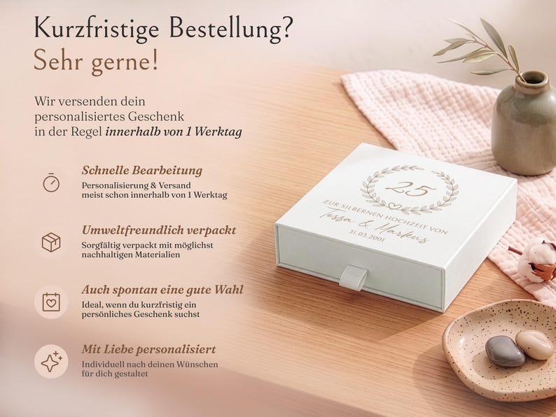 Pu&ograve; includere: Una scatola regalo quadrata bianca con cassetto estraibile, decorata con una corona stampata, il numero 25 e il testo "Zur silbernen Hochzeit von Tessa & Markus 31.03.2001". La scatola presenta una piccola linguetta in tessuto bianco sul davanti.