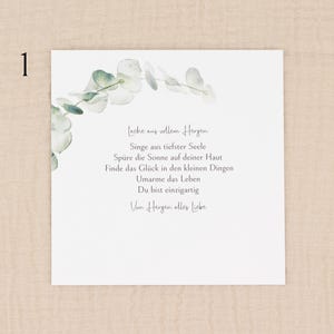 May include: A white card with a watercolor eucalyptus design and the number "1" in the upper left corner. The card features German text in a delicate script, including phrases like "Lache aus vollem Herzen" and "Du bist einzigartig."