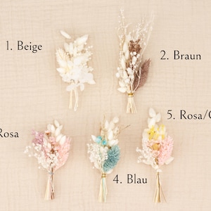 May include: Five small dried flower bouquets in beige, brown, pink, blue, and pink/yellow. Each bouquet is tied with natural twine. The bouquets are arranged on a neutral background, with the color names labeled.