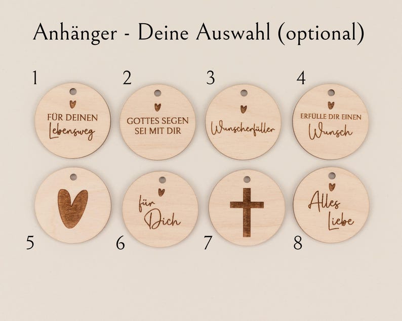 May include: A collection of eight wooden round pendants with various engraved designs and text. The pendants include a heart, a cross, and phrases like "For your journey" and "All love". Each pendant has a small hole at the top for hanging.