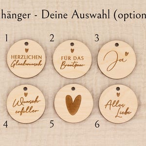 May include: Wooden round tags with various engraved messages and designs. The tags include phrases like "Congratulations," "For the Bride and Groom," and "All Love," along with a heart symbol. Each tag has a small hole for hanging.
