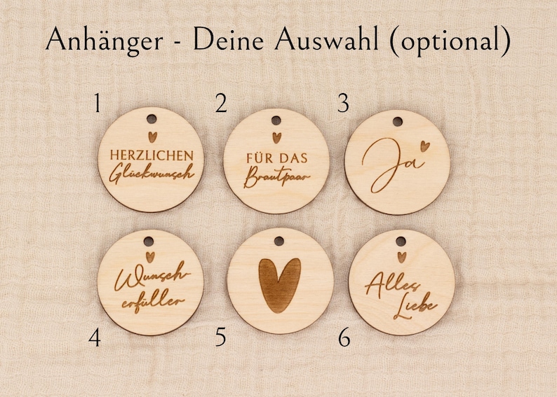 May include: Wooden round tags with various engraved messages and designs. The tags include phrases like "Congratulations," "For the Bride and Groom," and "All Love," along with a heart symbol. Each tag has a small hole for hanging.
