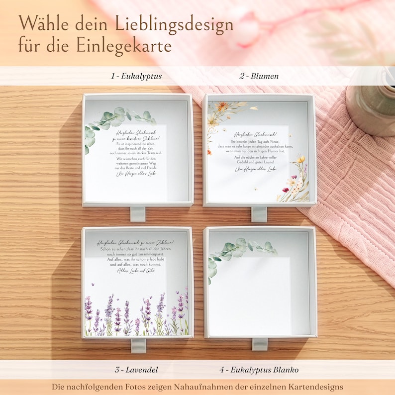 Pu&ograve; includere: Quattro scatole regalo quadrate bianche con cassetti estraibili, contenenti ciascuna un biglietto con testo in tedesco e illustrazioni botaniche. I disegni includono eucalipto, fiori e lavanda, con un'opzione di biglietto vuoto.