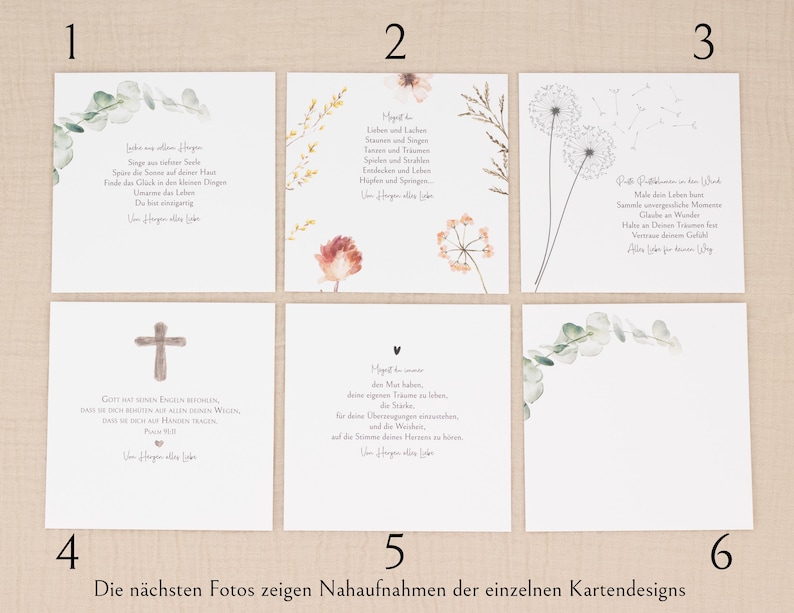 May include: A collection of six white cards with various designs. Some cards feature floral arrangements, while others have text in German. One card displays a cross, and another has a heart symbol. The cards are arranged on a light beige surface.