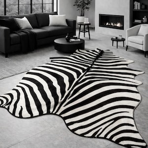 Puede incluir: Una alfombra con estampado de cebra en blanco y negro en un salón moderno. La alfombra es el punto focal, con un patrón audaz. La habitación cuenta con un sofá negro, una mesa de centro redonda y una chimenea, todo en una combinación de colores monocromáticos.