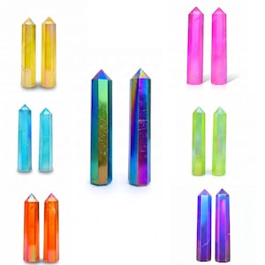 May include: A collection of polished crystal points arranged in pairs, featuring a vibrant iridescent finish. The set includes columns in yellow, pink, blue, green, orange, and multi-colored metallic hues, each with a pointed hexagonal top.