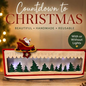 May include: A wooden Christmas countdown calendar featuring a red frame, a Santa in a sleigh, and a row of green trees. The top edge displays numbers 1 through 24. Text reads: Countdown to CHRISTMAS, BEAUTIFUL &bull; HANDMADE &bull; REUSABLE, and With or Without Lights.