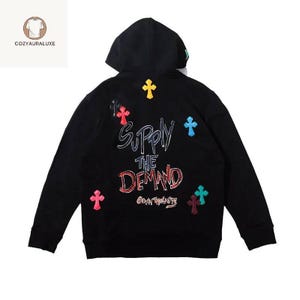 Sweat à capuche streetwear graphique - Lettres brodées audacieuses et patchs croisés colorés Pull unisexe surdimensionné