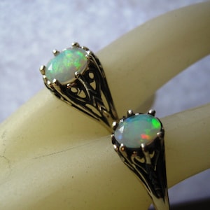 Puede incluir: Dos anillos de plata con piedras preciosas de &oacute;palo. Los anillos tienen un dise&ntilde;o filigranado intrincado.