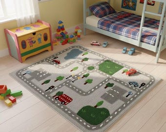 May include: A gray road rug with a city design, featuring roads, trees, and a green park area. Toy cars are scattered on the rug. A wooden toy chest and a bunk bed are in the background, creating a playful children's room setting.