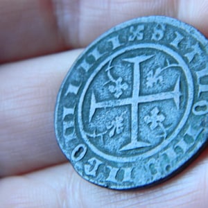 Auténtica ficha medieval de bronce con forma de cruz, encontrada mediante detección de metales.
