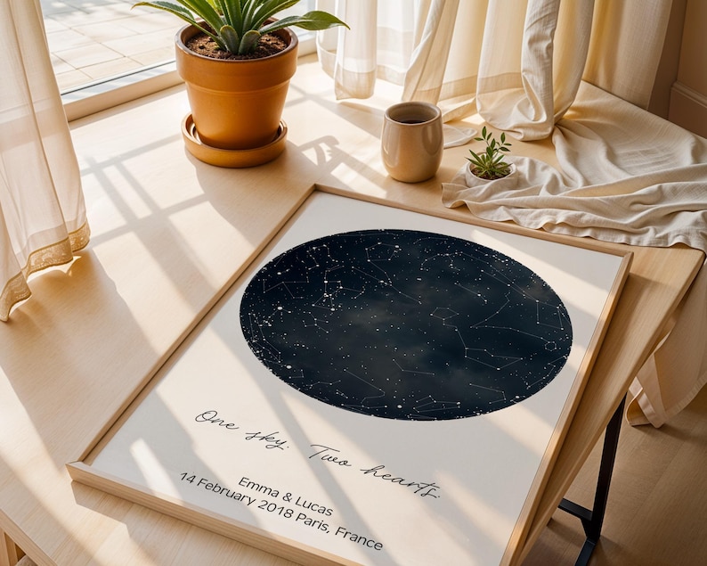 Peut inclure: Une impression encadr&eacute;e repr&eacute;sentant une carte c&eacute;leste bleu fonc&eacute; avec des &eacute;toiles blanches. L'impression comprend le texte "One sky. Two hearts." et les noms "Emma & Lucas" avec la date "14 f&eacute;vrier 2018 Paris, France."