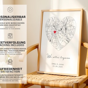 May include: A framed print featuring a heart-shaped map with a red heart marking a location. The print includes the text "Wo alles begann" and names with a date. The print is displayed on a wooden chair.