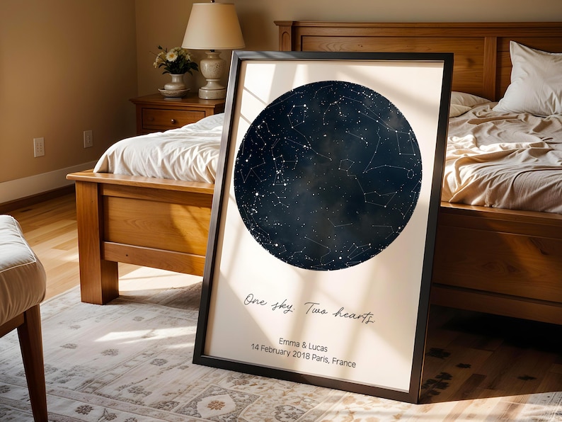 Peut inclure: Impression encadr&eacute;e repr&eacute;sentant une carte c&eacute;leste bleu fonc&eacute; avec des &eacute;toiles blanches. L'impression comprend le texte "One sky. Two hearts" et les noms Emma & Lucas, ainsi que la date du 14 f&eacute;vrier 2018 et le lieu Paris, France.