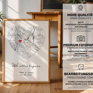 May include: Framed print featuring a heart-shaped map with a red marker, likely a location. The print includes the text "Wo alles begann" and a date. The frame is a light brown color.