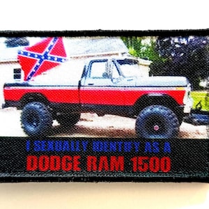 Peut inclure: Écusson rectangulaire représentant un pick-up Dodge Ram 1500 rouge et blanc avec un drapeau confédéré à l'arrière. Le texte "I SEXUALLY IDENTIFY AS A DODGE RAM 1500" est imprimé en bleu et rouge.