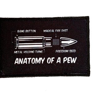 Puede incluir: Parche rectangular negro con texto blanco y un diagrama de una bala. El texto incluye "BANG BUTTON", "MAGICAL FIRE DUST", "METAL HOLDING THING", "FREEDOM SEED" y "ANATOMY OF A PEW".