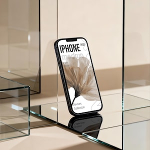May include: A black iPhone mockup with the text "IPHONE mockup" and "Devices Collection" displayed on the screen. The phone is angled, showcasing a floral design. The background features glass blocks and a neutral color palette.