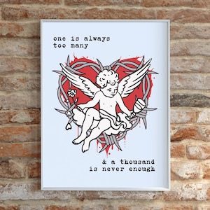 Può includere: Stampa artistica incorniciata con un cherubino bianco alato che tiene un'arma, su un cuore rosso e filo spinato. Il testo recita: "one is always too many & a thousand is never enough."