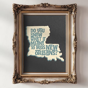 May include: Framed art print featuring a map of Louisiana with the text "Do you know what it means to miss New Orleans?" in a vintage font. The print is in a gold ornate frame, perfect for home decor.