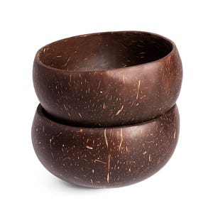 Może przedstawiać: Dwie ciemnobrązowe miski kokosowe ułożone jedna na drugiej. Miski mają gładki, zaokrąglony kształt z naturalną, nakrapianą fakturą. Wnętrze misek jest ciemniejsze.