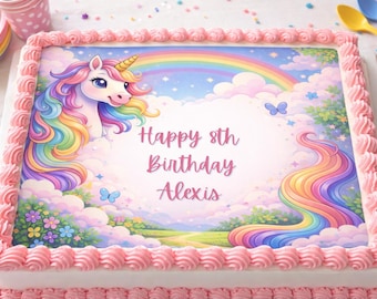 May include: A rectangular birthday cake with pink frosting and a colorful unicorn design. The cake features a rainbow, clouds, and the text "Happy 8th Birthday Alexis."