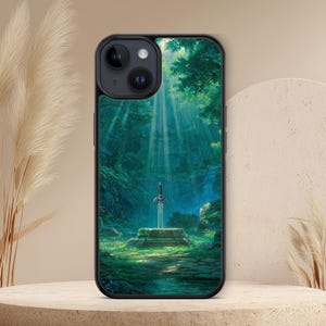 Op de afbeelding: Zwarte telefoonhoes met een fantasielandschap met een zwaard in een steen. De afbeelding toont zonlicht dat door de bomen schijnt. De hoes is ontworpen voor een smartphone.