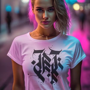 Può includere: Una donna indossa una maglietta bianca con un disegno gotico nero. Si trova in una strada con luci al neon. Indossa anche una collana d'oro. Lo sfondo è sfocato.