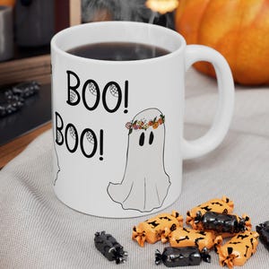 Taza de cerámica, fantasma gracioso con un anillo de flores en la cabeza, texto en letras espeluznantes, Halloween femenino. Taza de Halloween, Café espeluznante.