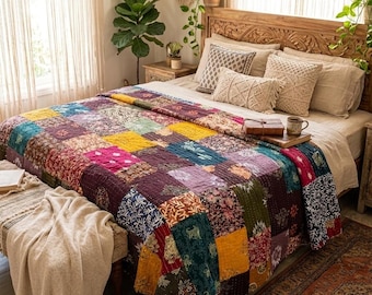 Puede incluir: Una colcha de patchwork que presenta una variedad de cuadrados de tela coloridos con patrones florales y geométricos en tonos amarillo, rojo intenso, morado y verde azulado, sobre una cama con almohadas de tonos neutros y un cabecero de madera.