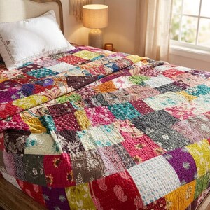 Puede incluir: Una colcha de retazos que presenta una variedad de parches de tela cuadrados en colores vibrantes que incluyen rojo, amarillo, morado, verde azulado y negro. La colcha muestra diversos patrones florales y de cachemira con costuras blancas visibles.