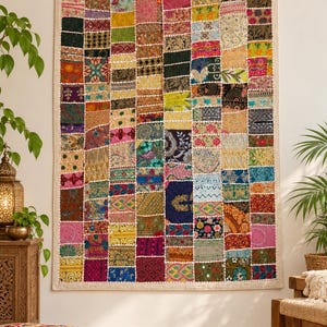 May include: A rectangular wall hanging featuring a patchwork design composed of numerous small, multi-colored fabric squares. The textile displays a variety of patterns, including floral, geometric, and embroidered motifs in vibrant hues.